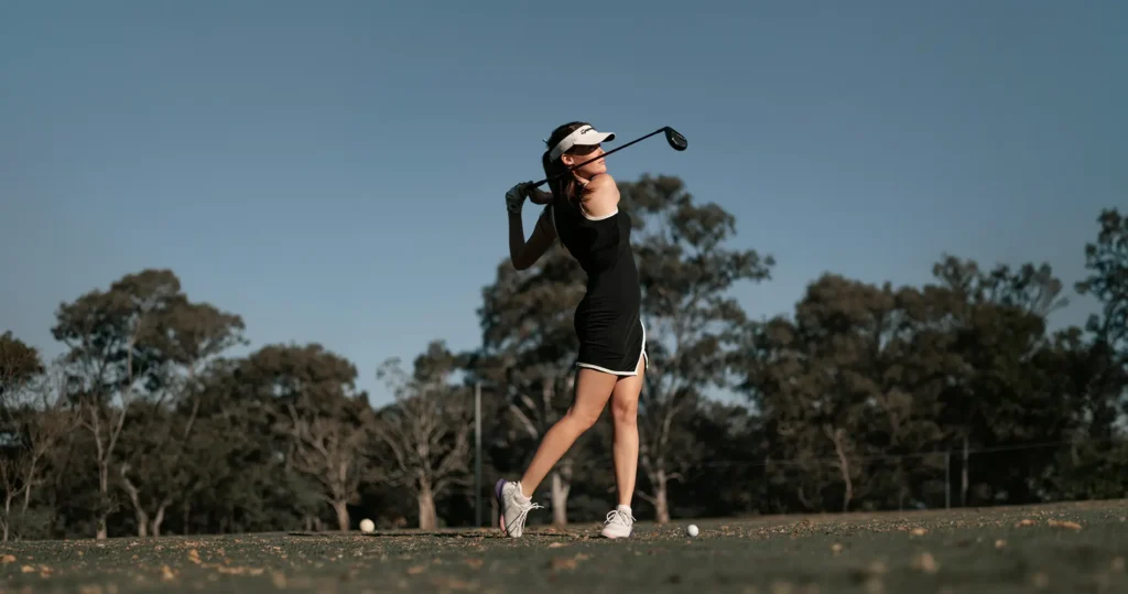 Woman golfing on a sunny day.