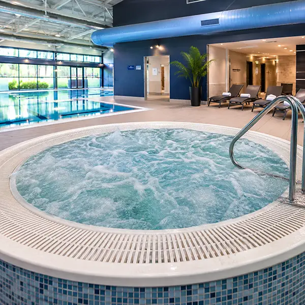 Why is legionella control more challenging for swimming pools? Woman using golf ball washer outdoors